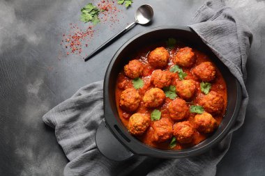 Baharat ile tatlı ve ekşi Domates sosu köfte koyu arka planda bir kızartma tavasında hizmet vermiştir. Üst görünüm 