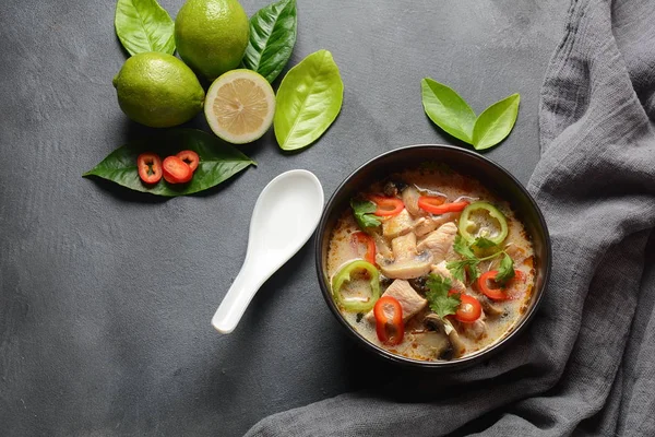 Thai style coconut milk soup-Tom Kha Gai with chicken,mushrooms, galangal, lime leaves, lemongrass, chili peppers. Thai cuisine food concept