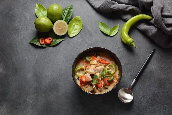 Thai style coconut milk soup-Tom Kha Gai with chicken,mushrooms, galangal, lime leaves, lemongrass, chili peppers. Thai cuisine food concept