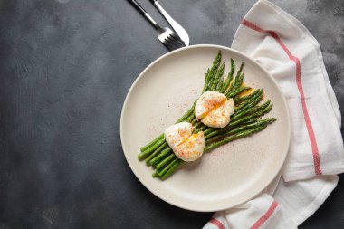 Bir tabakta haşlanmış yumurta ile yeşil kuşkonmaz. Sağlıklı kahvaltı konsepti