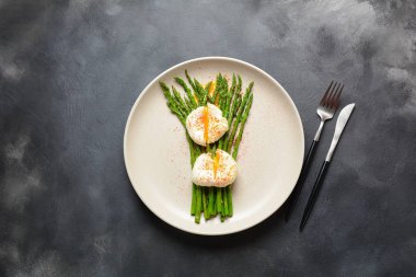 Bir tabakta haşlanmış yumurta ile yeşil kuşkonmaz. Sağlıklı kahvaltı konsepti