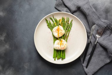 Bir tabakta haşlanmış yumurta ile yeşil kuşkonmaz. Sağlıklı kahvaltı konsepti
