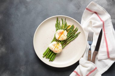 Bir tabakta haşlanmış yumurta ile yeşil kuşkonmaz. Sağlıklı kahvaltı konsepti