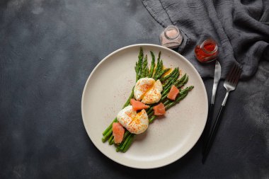 Bir tabakta haşlanmış yumurta ile yeşil kuşkonmaz. Sağlıklı kahvaltı konsepti