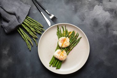 Bir tabakta haşlanmış yumurta ile yeşil kuşkonmaz. Sağlıklı kahvaltı konsepti