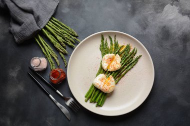 Bir tabakta haşlanmış yumurta ile yeşil kuşkonmaz. Sağlıklı kahvaltı konsepti