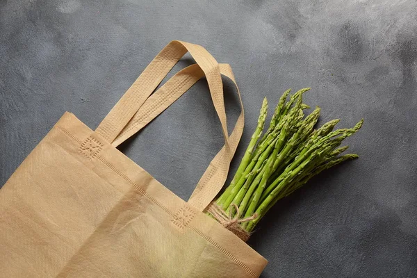 Reusable zero waste textile product bag filled with green asparagus