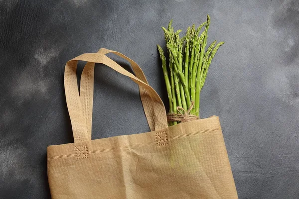 Reusable zero waste textile product bag filled with green asparagus