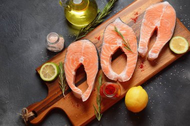 Lezzetli somon biftek , omega 3 yağı açısından zengin, limon, aromatik otlar ve baharatlar siyah arka plan. Sağlıklı ve diyet gıda. 