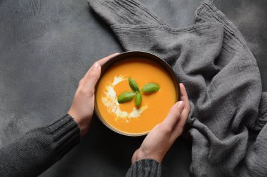 Elinde kabak ve havuç kremaçorbası kase. Sonbahar sıcak vegan çorba konsepti