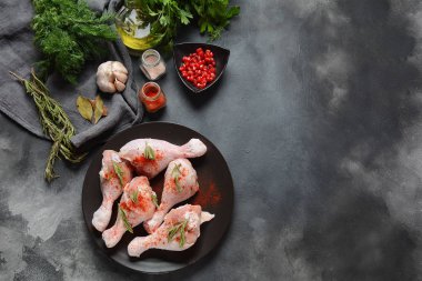 Tuz, otlar, sarımsak ve zeytinyağı ile barbekü ızgara için çiğ pişmemiş tavuk bacakları. Pişirme için malzemelerle et