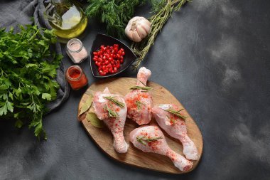 Tuz, otlar, sarımsak ve zeytinyağı ile barbekü ızgara için çiğ pişmemiş tavuk bacakları. Pişirme için malzemelerle et