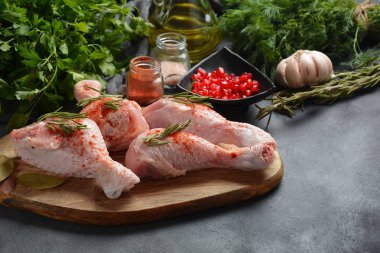 Tuz, otlar, sarımsak ve zeytinyağı ile barbekü ızgara için çiğ pişmemiş tavuk bacakları. Pişirme için malzemelerle et