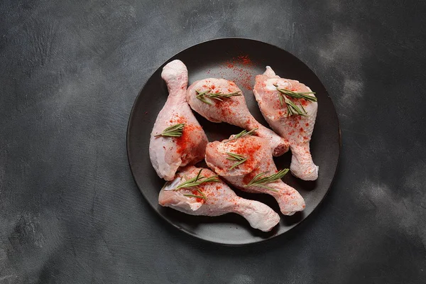 Raw uncooked chicken legs for barbecue grill with salt, herbs, garlic and olive oil. Meat with ingredients for cooking