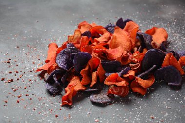 Fırında sebze cips- garnet tatlı patates, mor tatlı patates, havuç ve pancar. Glutensiz, sütsüz ve vegan. Sağlıklı gıda kavramı