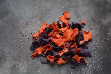 Fırında sebze cips- garnet tatlı patates, mor tatlı patates, havuç ve pancar. Glutensiz, sütsüz ve vegan. Sağlıklı gıda kavramı