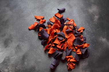 Fırında sebze cips- garnet tatlı patates, mor tatlı patates, havuç ve pancar. Glutensiz, sütsüz ve vegan. Sağlıklı gıda kavramı