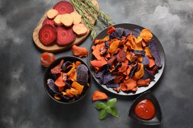 Fırında sebze cips- garnet tatlı patates, mor tatlı patates, havuç ve pancar. Glutensiz, sütsüz ve vegan. Sağlıklı gıda kavramı