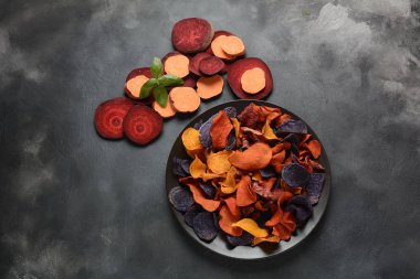 Fırında sebze cips- garnet tatlı patates, mor tatlı patates, havuç ve pancar. Glutensiz, sütsüz ve vegan. Sağlıklı gıda kavramı