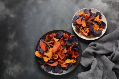 Fırında sebze cips- garnet tatlı patates, mor tatlı patates, havuç ve pancar. Glutensiz, sütsüz ve vegan. Sağlıklı gıda kavramı