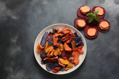 Fırında sebze cips- garnet tatlı patates, mor tatlı patates, havuç ve pancar. Glutensiz, sütsüz ve vegan. Sağlıklı gıda kavramı