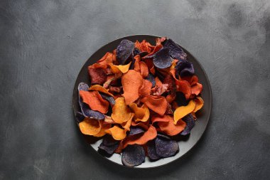 Fırında sebze cips- garnet tatlı patates, mor tatlı patates, havuç ve pancar. Glutensiz, sütsüz ve vegan. Sağlıklı gıda kavramı