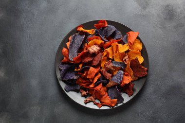Fırında sebze cips- garnet tatlı patates, mor tatlı patates, havuç ve pancar. Glutensiz, sütsüz ve vegan. Sağlıklı gıda kavramı