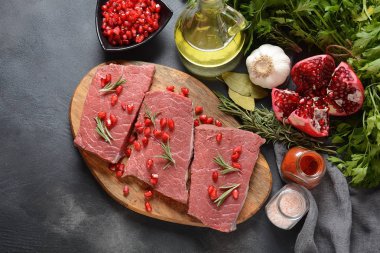 İçindekilerle, baharatlarla, baharatlarla ve narlarla dilimlenmiş çiğ et.