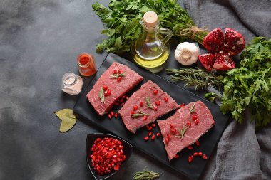 İçindekilerle, baharatlarla, baharatlarla ve narlarla dilimlenmiş çiğ et.