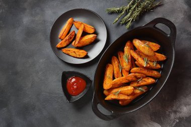 Fırında, baharatlı ve biberiyeli kızarmış patates dilimleri. 