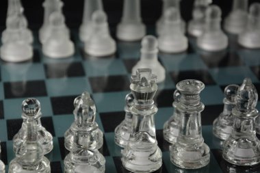 Siyah arka planda izole edilmiş cam satranç tahtasındaki cam parçaları temizle.