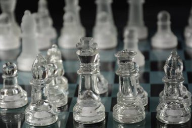 Siyah arka planda izole edilmiş cam satranç tahtasındaki cam parçaları temizle.