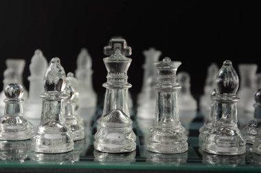 Siyah arka planda izole edilmiş cam satranç tahtasındaki cam parçaları temizle.