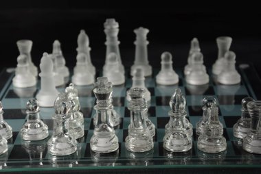 Siyah arka planda izole edilmiş cam satranç tahtasındaki cam parçaları temizle.