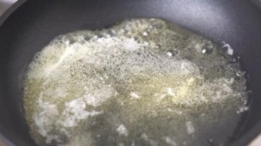 Erimiş tereyağı sıcak tavada yavaşça kızarır ve erir. Eriyen tereyağlı kızartma tavası. 