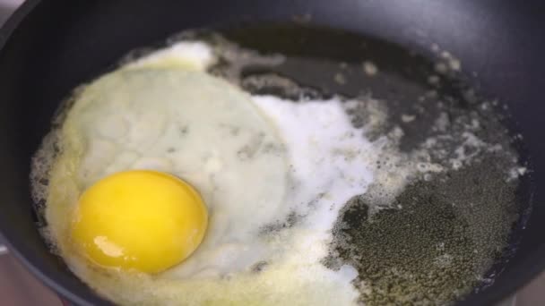 Deuxième oeuf de poulet mis dans une poêle noire .