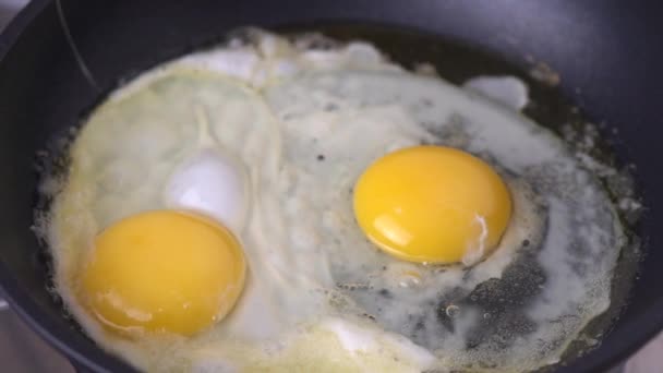 Two Eggs Frying Black Pan — Stock Video