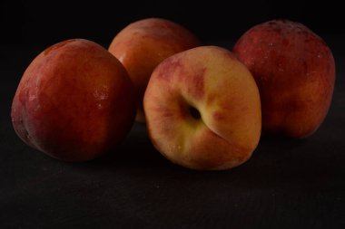 Şeftaliler karanlık arka planda. Olgun şeftalili kompozisyon. Yiyecek ya da meyve suyu için şeftali hasadı. Üst manzara taze organik meyve, vejetaryen yiyecekler..