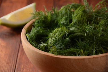 Tahta kapta taze dereotu ve ahşap arka planda limon. Kırsal biçim