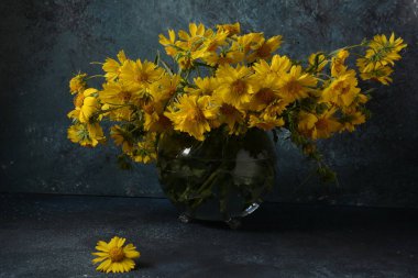 Bouquet of Doronicumflowers ( sunflower family )in a transparent glass flower vase. clipart