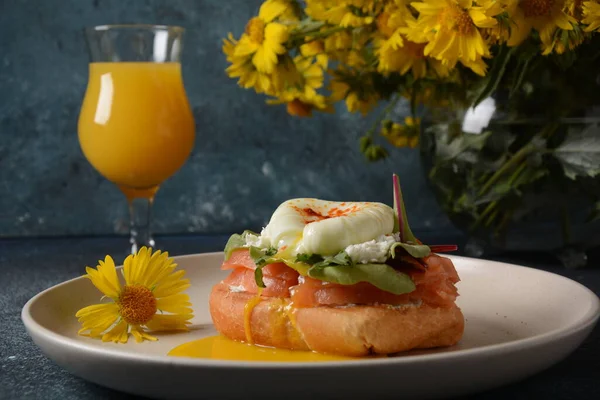 シリアルパンとサーモンのサンドイッチで朝食 ソフトチーズとポーチドエッグとオレンジジュースのガラス — ストック写真