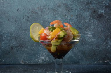 Koyu veya gri arka planda karides, portakal ve avokado kaplı Ceviche salatası. Latin Amerika yemekleri. Lezzetli, taze yapılmış karides ceviche. Limon ve portakalla marine edilmiş karides. .