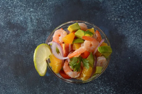 Koyu veya gri arka planda karides, portakal ve avokado kaplı Ceviche salatası. Latin Amerika yemekleri. Lezzetli, taze yapılmış karides ceviche. Limon ve portakalla marine edilmiş karides. .