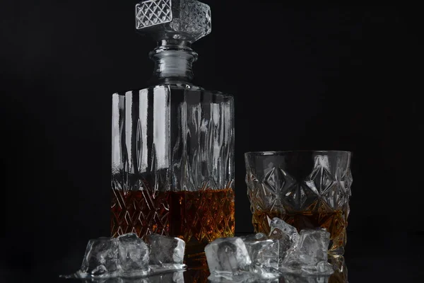 黒の背景に氷のキューブと正方形のデカンタとウイスキーのガラス — ストック写真