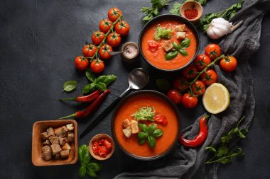 Endülüs usulü gazpacho. Bardakta soğuk kırmızı domates çorbası, salatalık, soğan, fesleğen, acı biber ve kızarmış ekmek..