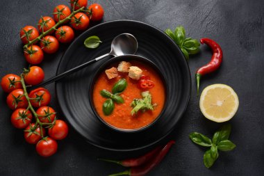 Endülüs usulü gazpacho. Bardakta soğuk kırmızı domates çorbası, salatalık, soğan, fesleğen, acı biber ve kızarmış ekmek..