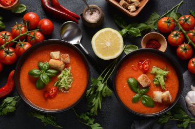 Endülüs usulü gazpacho. Bardakta soğuk kırmızı domates çorbası, salatalık, soğan, fesleğen, acı biber ve kızarmış ekmek..