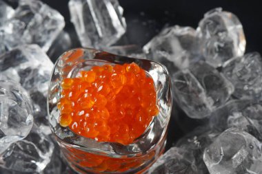 Kırmızı havyar ve buz kaplı bir kaşık. Yakın plan somon havyarı. Lezzetli