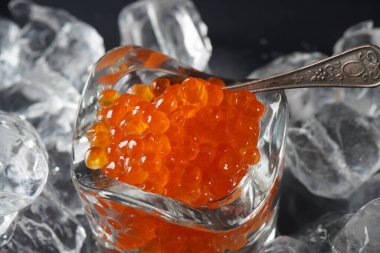 Kırmızı havyar ve buz kaplı bir kaşık. Yakın plan somon havyarı. Lezzetli