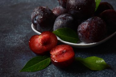 Bir tabakta sulu erikler. Taze Mavi Erikler. 